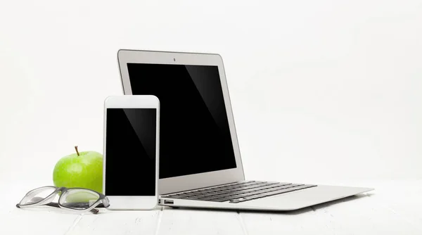 ノートパソコン スマートフォン 電源と白の背景にリンゴとオフィスの職場の机のテーブル テキストやアプリのスペースで — ストック写真