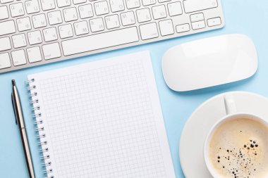 Bilgisayarlı, malzemeli ve kahveli mavi çalışma masası. Metnin için en üstte boşluk var. Düz yatıyordu