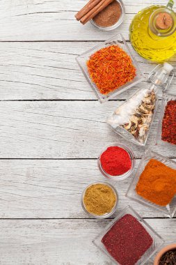 Beyaz ahşap masadaki çeşitli baharatlar. Hint mutfağı. Üst görünüm düzlüğü kopyalama alanı ile yatıyordu