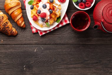 Yaz meyveleri, kruvasanlar ve kahvaltı çayıyla nefis Belçika waffleları. Kopyalama alanı olan üst görünüm