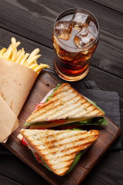 Kulüp sandviç, patates cipsi ve buzlu bir bardak kola. Fast food servisi. Üst görünüm