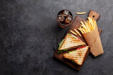 Kulüp sandviç, patates cipsi ve buzlu bir bardak kola. Fast food servisi. Kopyalama alanı olan üst görünüm