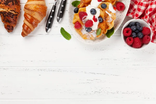 美味的比利时华夫饼和夏天的浆果和羊角面包 早餐甜点 带有复制空间的顶部视图 — 图库照片