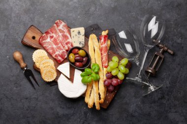 Peynir, et, üzüm ve zeytinli antipasto. Tahta üzerinde aperatif seçimi. Üst görünüm düzlüğü