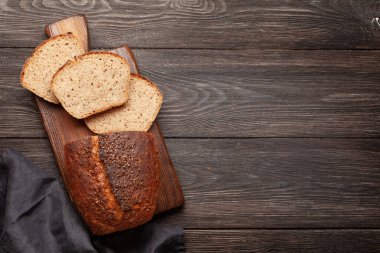 Tahta masadaki tohumlu ev yapımı organik ekmek. Üst görünüm düzlüğü kopyalama alanı ile yatıyordu