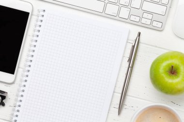 Ofis masasında bilgisayar, akıllı telefon, not defteri ve kahve. Metnin ya da uygulaman için en üstteki görünüm. Düz yatıyordu