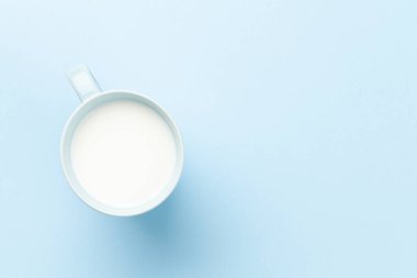 Mavi arka planda süt bardağı. Kopyalama alanı olan üst görünüm. Düz yatıyordu