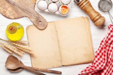 Ahşap arka planda mutfak aletleri ve malzemeler. Yemek kitabının olduğu en iyi manzara senin tarifin. Düz yatıyordu