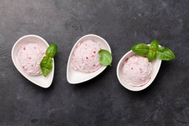 Ahududulu dondurma kepçeleri taştan arka planda kaselerde. Kopyalama alanı olan üst görünüm. Düz yatıyordu