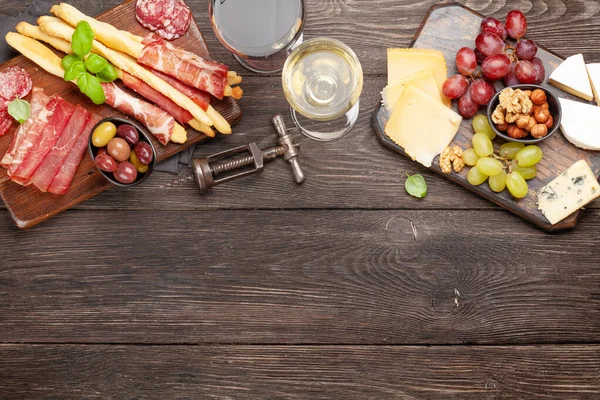 葡萄和橄榄选好的开胃菜放在木板上 配上红白相间的酒杯 带有复制空间的顶部视图 平躺在床上 — 图库照片