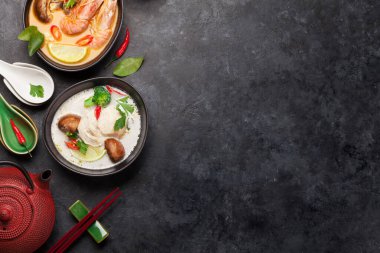 Tom Yum ve Tom Kha geleneksel deniz ürünleri, tavuk, mantar, hindistan cevizi sütü ve sıcak baharatlı Tayland çorbaları. Yeşil çayla. Kopyalama alanı olan üst görünüm