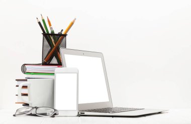 Laptop, akıllı telefon, malzeme ve beyaz arka planda kahve fincanı olan çalışma masası. Metnin ya da uygulaman için boşluk ile
