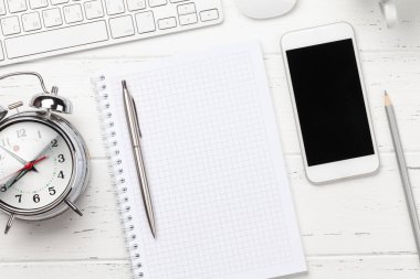 Ofis masasında akıllı telefon, erzak ve çalar saat var. Sabah ya da teslim tarihi konsepti. Metnin için en üstte boşluk var. Düz yatıyordu