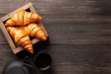 Taze kruvasan ve çay. Kahvaltı menüsü. Üst görünüm düzlüğü kopyalama alanı ile yatıyordu