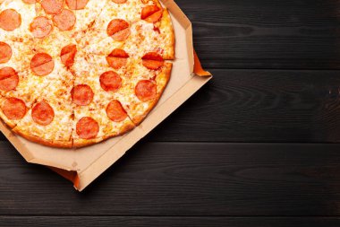 Kutusunda salam olan lezzetli biberli pizza. Kopyalama alanı olan üst görünüm. Düz yatıyordu