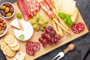 Peynir, et, üzüm ve zeytinli antipasto. Tahta üzerinde aperatif seçimi. Üst Manzara. Düz yatıyordu