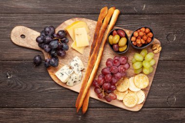 Peynir, üzüm ve zeytinli antipasto. Aperatif seçme tahtası. Üst görünüm yakın plan. Düz yatıyordu
