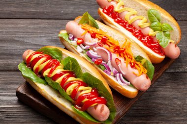 Tahtada sebzeli, marullu ve sosisli sandviç var.