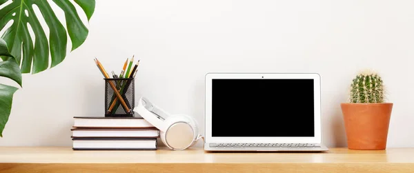 ノートパソコン 電源とヘッドフォンでスタイリッシュなホームスタジオワークスペース 家の概念からの仕事 テキストの空白の画面が表示される — ストック写真