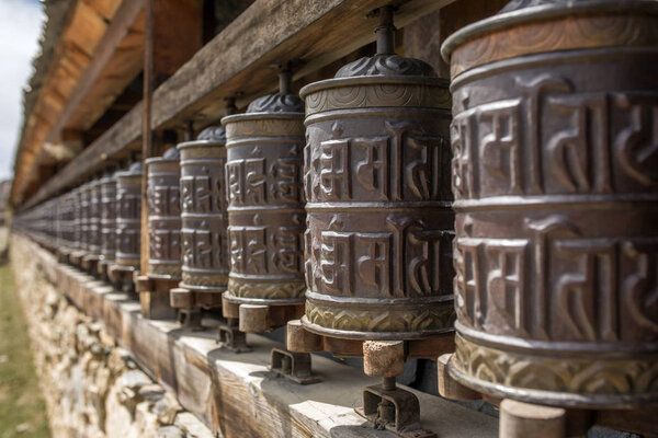 Buddhist prayer mani wall with prayer wheels