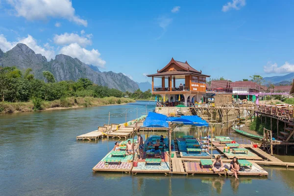 Turistas descansando en restaurante frente al río —  Fotos de Stock