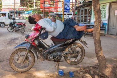 Monywa, Myanmar - 9 Ekim 2016: Monywa, Myanmar Park halindeki motosiklet üzerinde derin uykuya tanımlanamayan Birmanya erkekte.