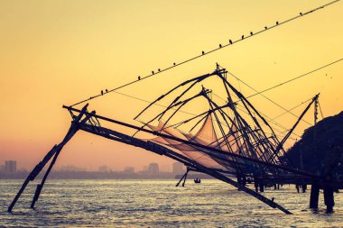 Chinese fishing net at sunrise in Cochin  clipart