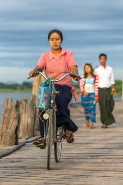 Amarapura, Myanmar - 1 Ekim 2016: Belirsiz Birmanya kadın binicilik bisiklet Amarapura Mandalay, Myanmar yakınındaki ünlü U-Bein köprüde
