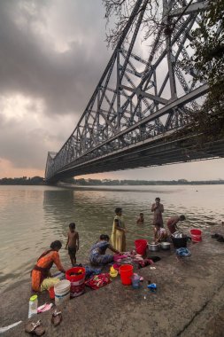 Kolkata, Hindistan - 6 Nisan 2017: Düşük açılı görünüş Howrah Bridge Hooghly nehrinde çamaşır insanlarla 