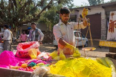 Barsana, Hindistan - 17 Mart 2016: Holi festival Hindistan için kullanılan renkli toz boya satış kimliği belirsiz adam