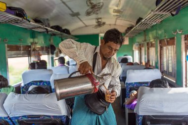 Yangon, Myanmar - October 15, 2016: Unidentified burmese man selling tea in the train in Myanmar. clipart