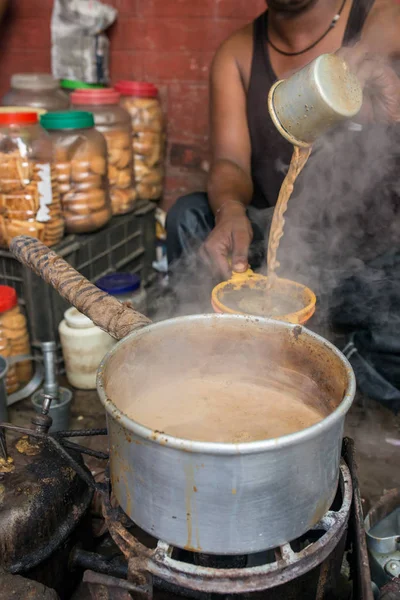 コルカタ インドの通りの彼の店で顧客のホットミルク ティー インド風チャイのカップを注ぐ男 — ストック写真