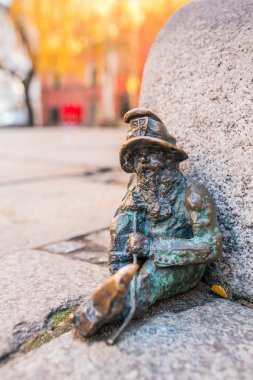 Wroclaw, Polonya bir sokakta katında oturan bir cüce küçük bakır heykeli. Wrocaws cücelerin ünlü turistik şehir bulunmaktadır. 