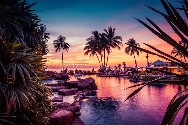 Impresionante vista al atardecer con palmeras reflejándose en la piscina en el resort de lujo en Tailandia — Foto de Stock