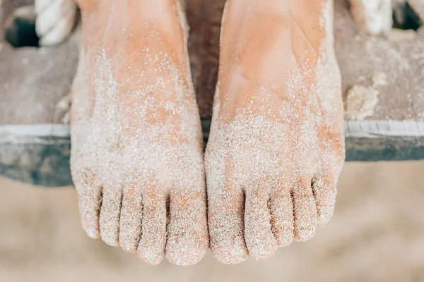 Nő homokos lábak fa hinta lóg a strandon — Stock Fotó