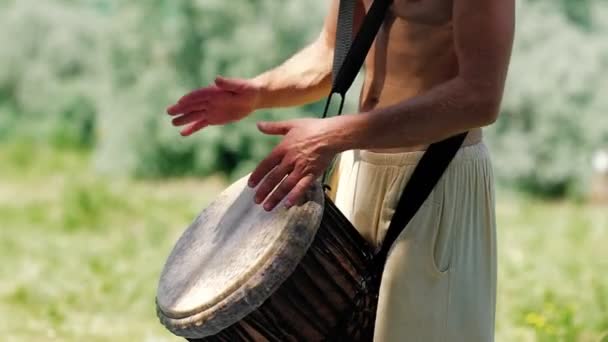 Неопознанный кавказский человек играет на африканском барабане Джембе — стоковое видео