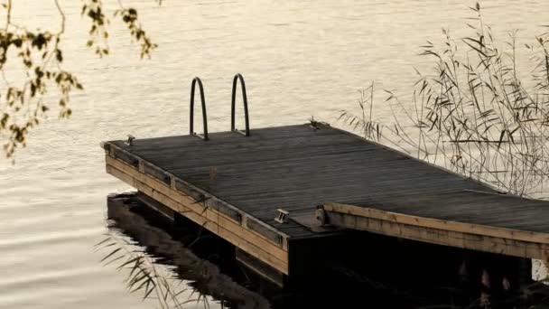 Kleine houten pier aan een rustig meer bij zonsondergang in Finland — Stockvideo