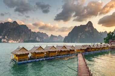 Gün batımında Khao Sok Ulusal Parkı 'ndaki Cheow Lan Gölü' ndeki salt evleri.