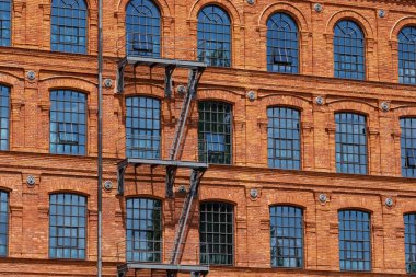 Red brick classic industrial building facade with multiple windows background.  clipart