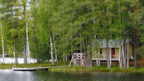 Casa de madeira na margem do lago — Vídeo de Stock