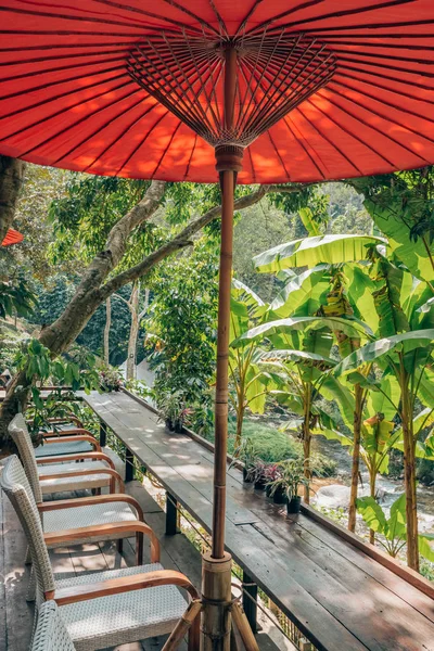 Beautiful outdoor cafe with traditional red Thai umbrellas in Thailand. — Stock fotografie