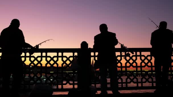 Nelayan Turki tak dikenal di jembatan Galata saat senja di Istanbul — Stok Video