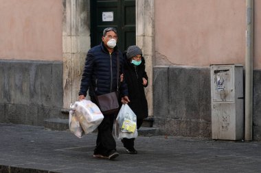 İtalya 'da Coronavirus. Kimliği belirsiz kişiler koruyucu maske takıyor. 