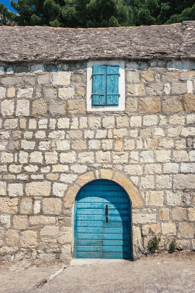 Παραδοσιακό πέτρινο σπίτι με μπλε πόρτα και παράθυρο στην Κροατία — Φωτογραφία Αρχείου
