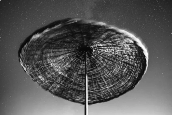 Ομπρέλα παραλίας με νυχτερινό ουρανό γεμάτο αστέρια. — Φωτογραφία Αρχείου