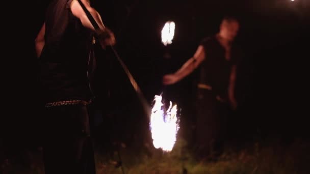 Artistas irreconocibles realizan espectáculo de fuego al aire libre con fuego por la noche — Vídeos de Stock