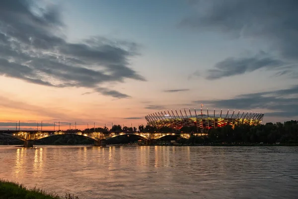 Pohled na národní stadion a most přes řeku Vislu za soumraku ve Varšavě, Polsko — Stock fotografie