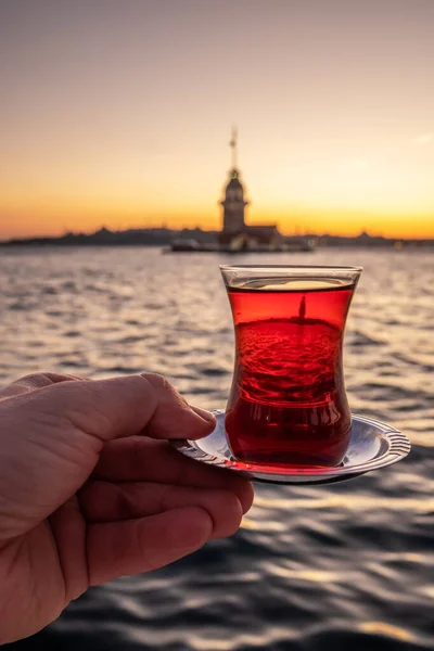 Té turco tradicional en un vaso con la Torre de la Doncella al fondo en Estambul, Turquía — Foto de Stock