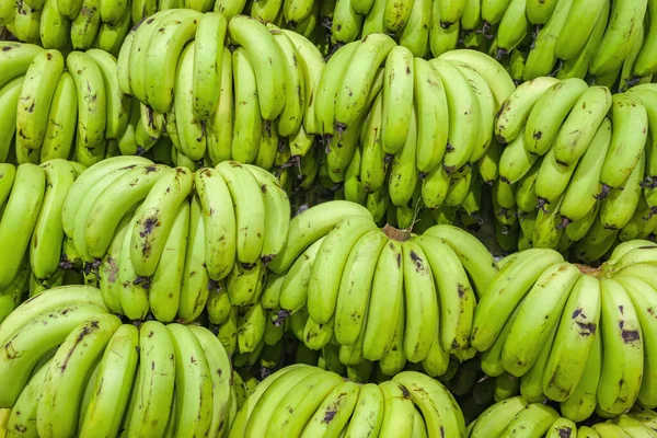 Bando de bananas verdes na banca do mercado indiano — Fotografia de Stock