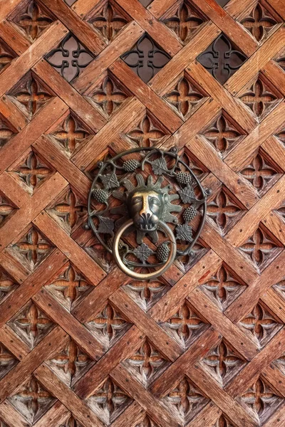 Porta de madeira medieval velha com batedor de porta de metal em forma de cabeça de leão — Fotografia de Stock